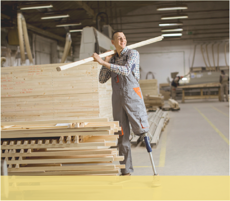 Man with a leg amputation holding lumber in a warehouse